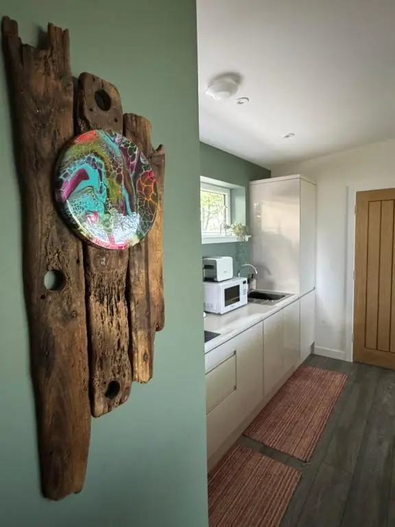 a kitchen with a wooden artifact hanging on the wall at Wellhouse Country Lodges and Hot Tubs in Tore