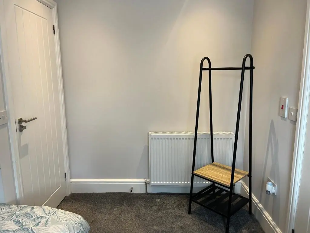 a black chair in a room with a wall at Fairfield Cottage Rooms in Inverness