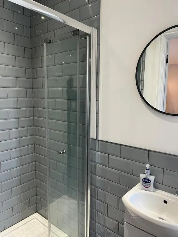 a bathroom with a glass shower and a sink at Fairfield Cottage Rooms in Inverness