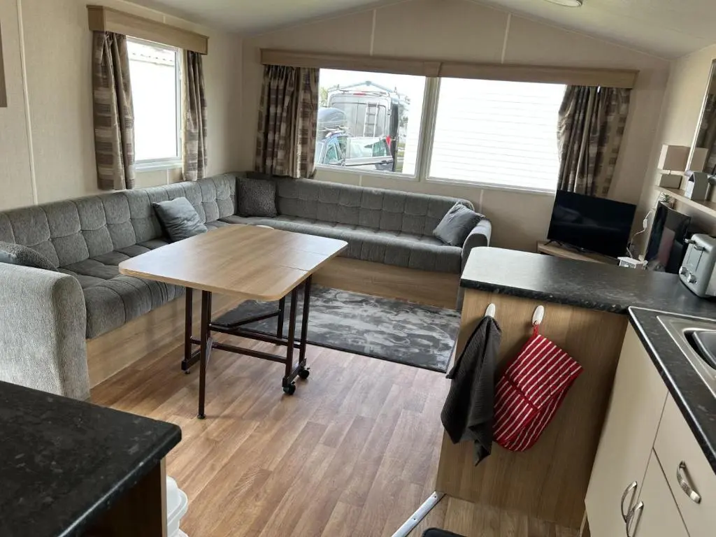 a living room with a couch and a table at A13 - Beach Haven at Silversands in Lossiemouth