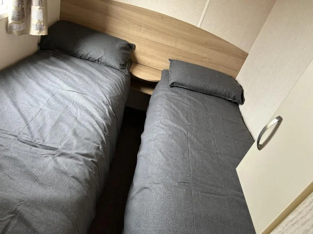 a small bedroom with a bed and a table at A13 - Beach Haven at Silversands in Lossiemouth
