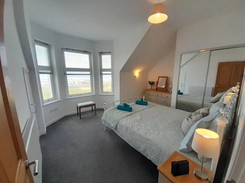 a bedroom with a large bed and a large mirror at Seabreeze in Whitehills