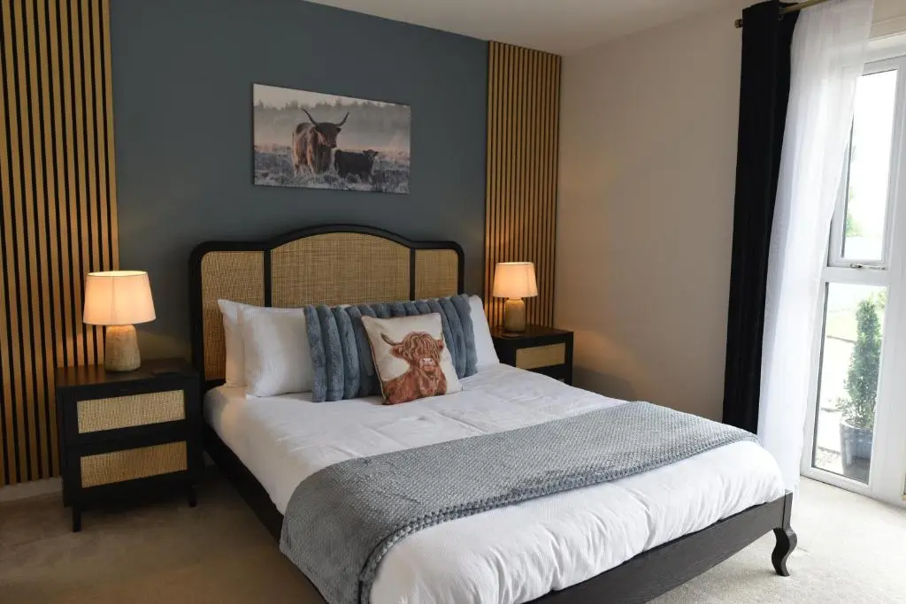 a bedroom with a bed with a teddy bear on it at Coille Burn in Urray