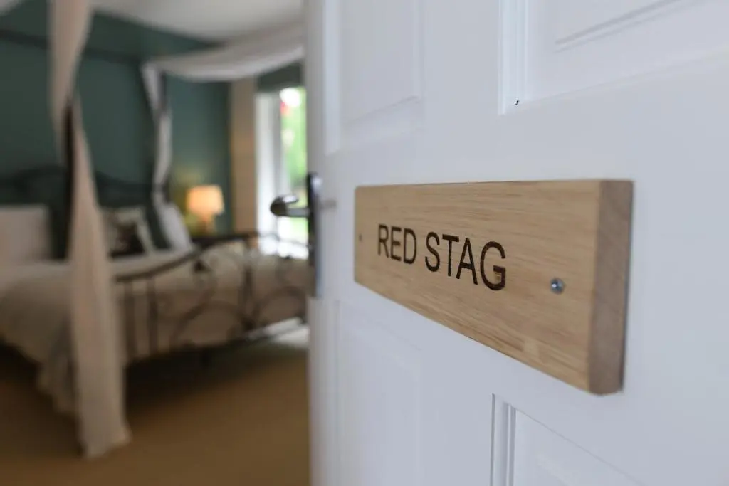 a door sign that reads red stag in a bedroom at Coille Burn in Urray