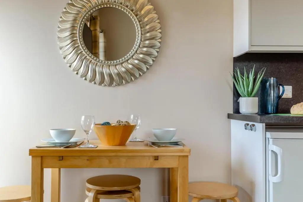 a mirror on a wall above a wooden table at 2 Bed in Cromarty oc-s32047 in Cromarty