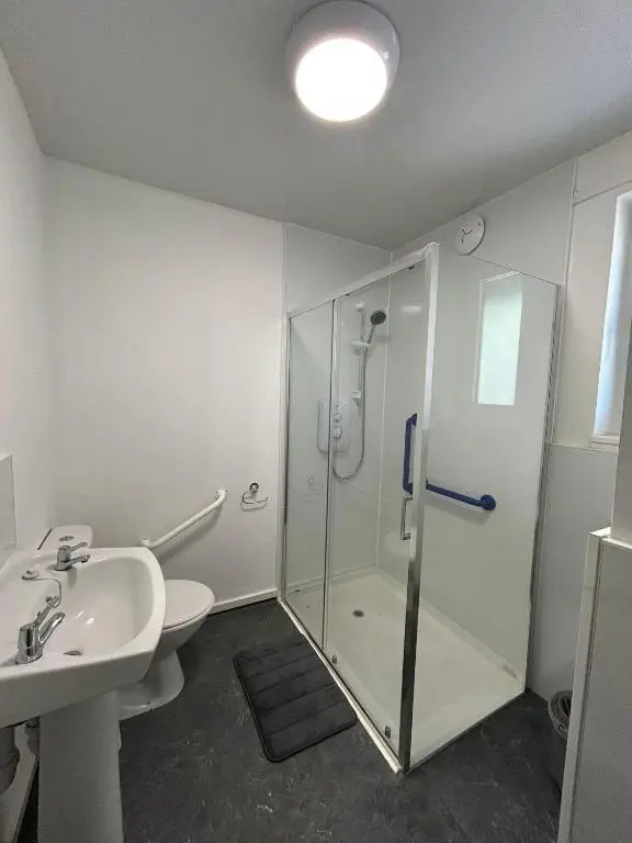 a bathroom with a shower and a toilet and a sink at Two bedroom cottage in Lumsden - Contractors in Huntly