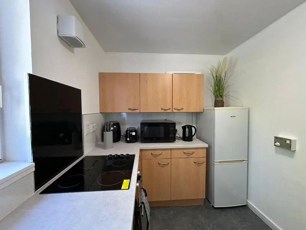 a small kitchen with a refrigerator and a stove at Two bedroom cottage in Lumsden - Contractors in Huntly