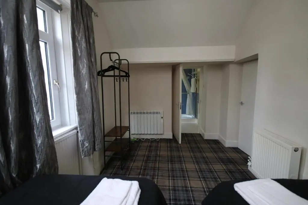 a room with two beds and a hallway with a window at Stag View in Garve