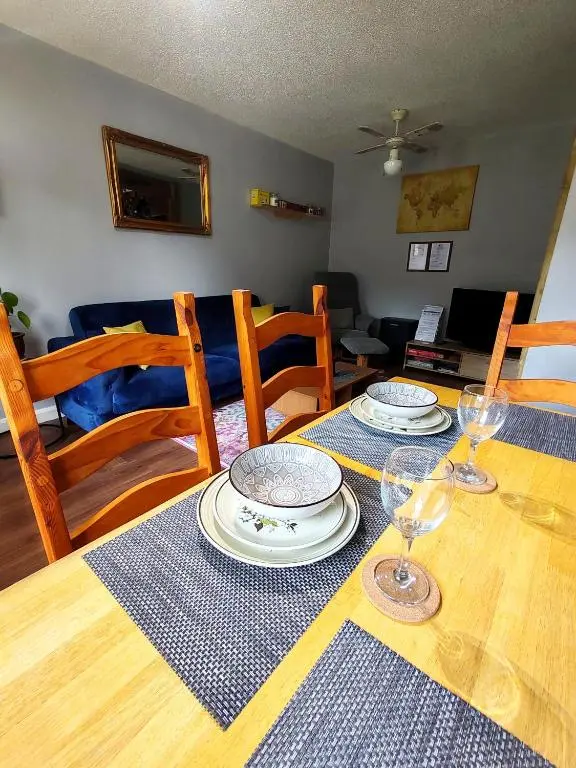 a dining room table with two plates and wine glasses at Private Holiday Home in Inverness with Free Parking l Sleeps 4 in Dalneigh