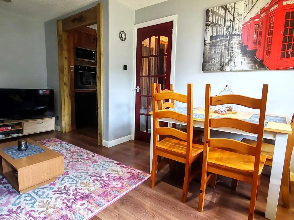 a living room with a dining room table and chairs at Private Holiday Home in Inverness with Free Parking l Sleeps 4 in Dalneigh