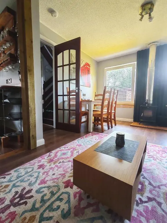 a living room with a table and a dining room at Private Holiday Home in Inverness with Free Parking l Sleeps 4 in Dalneigh