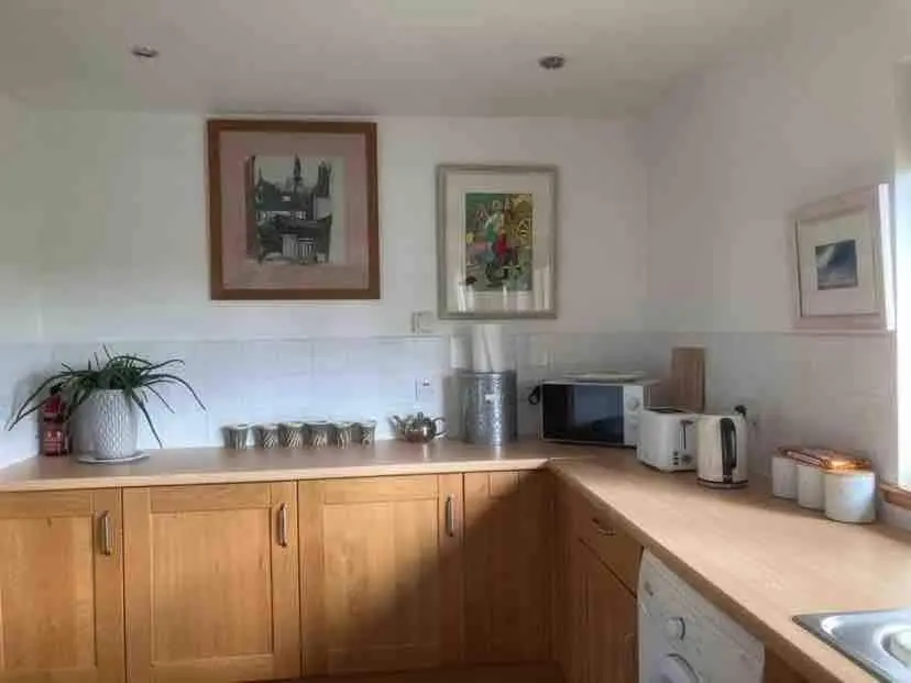 a kitchen with wooden cabinets and a counter top at East Cottage, Brodie in Dyke
