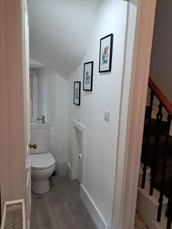 a bathroom with a toilet and pictures on the wall at Granny's Hoose in Wick