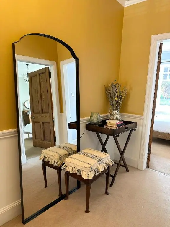 a dressing room with a mirror and a bench and a table at Ladies Walk - Stunning Riverfront Home in Inverness
