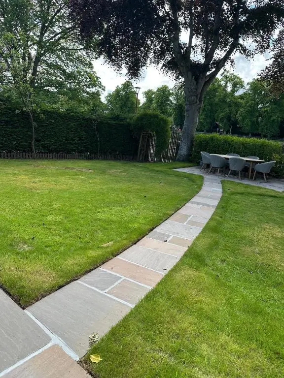 a garden with a table and chairs in the grass at Ladies Walk - Stunning Riverfront Home in Inverness