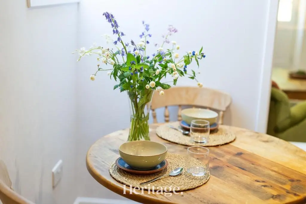 a wooden table with a vase of flowers on it at The Byre, Countryside Home in Tough