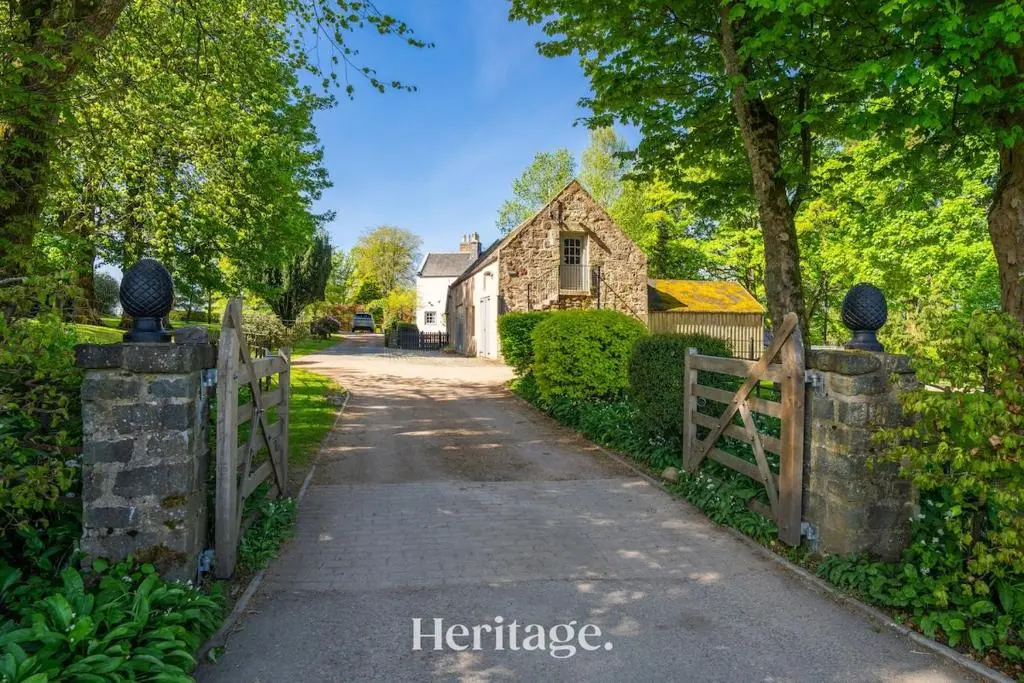 a driveway leading to a house with a wooden fence at The Byre, Countryside Home in Tough