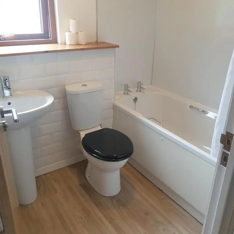 a bathroom with a toilet and a sink and a bath tub at 1 Bed Apartment Inverness with City Views in Inverness
