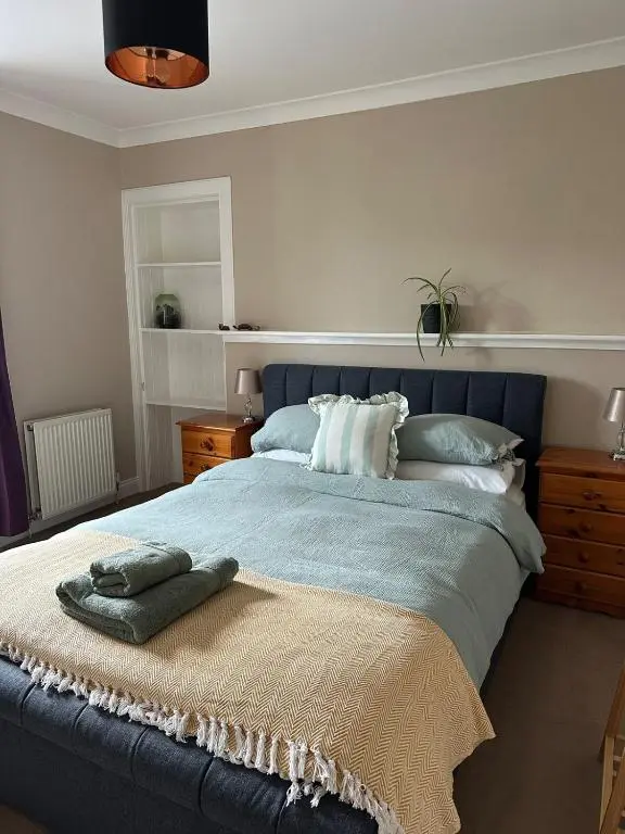 a bedroom with a large bed with pillows on it at Serendipity The Apartment in South Kessock