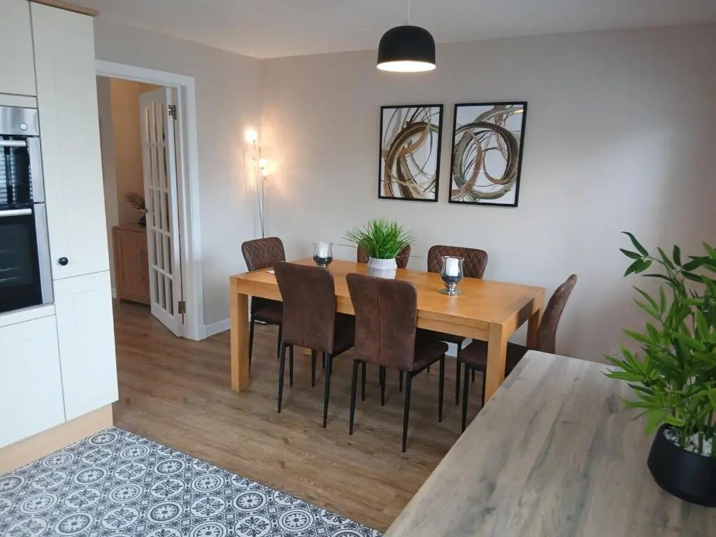 a dining room with a wooden table and chairs at Newly refurbished 3 bed house in Inverness
