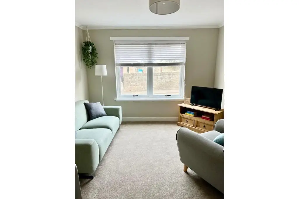 a living room with two couches and a television at Flat by the Firth - Stay in the heart of Nairn in Nairn