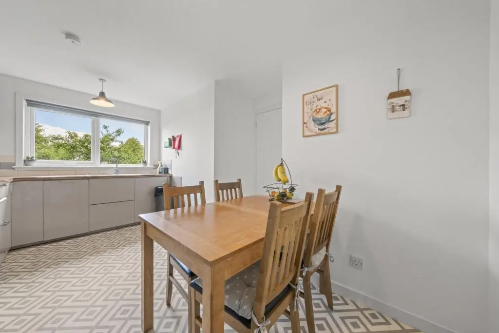 a kitchen and dining room with a wooden table and chairs at Heather 3 Bedroom House - Inverness in Inverness