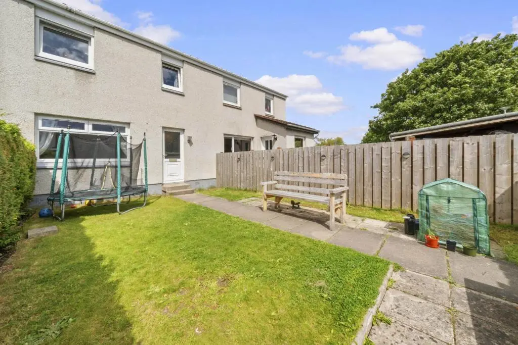 a wooden bench in a yard next to a fence at Heather 3 Bedroom House - Inverness in Inverness