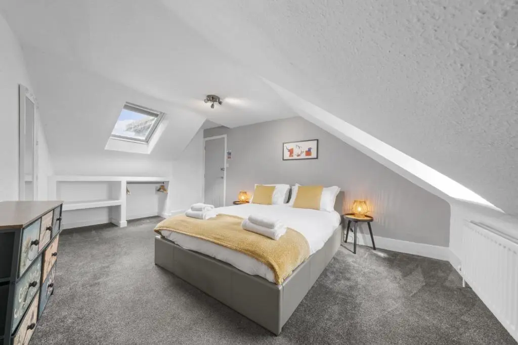 a white bedroom with a bed and a staircase at Crown 3 Bedroom Apartment - Inverness in Inverness