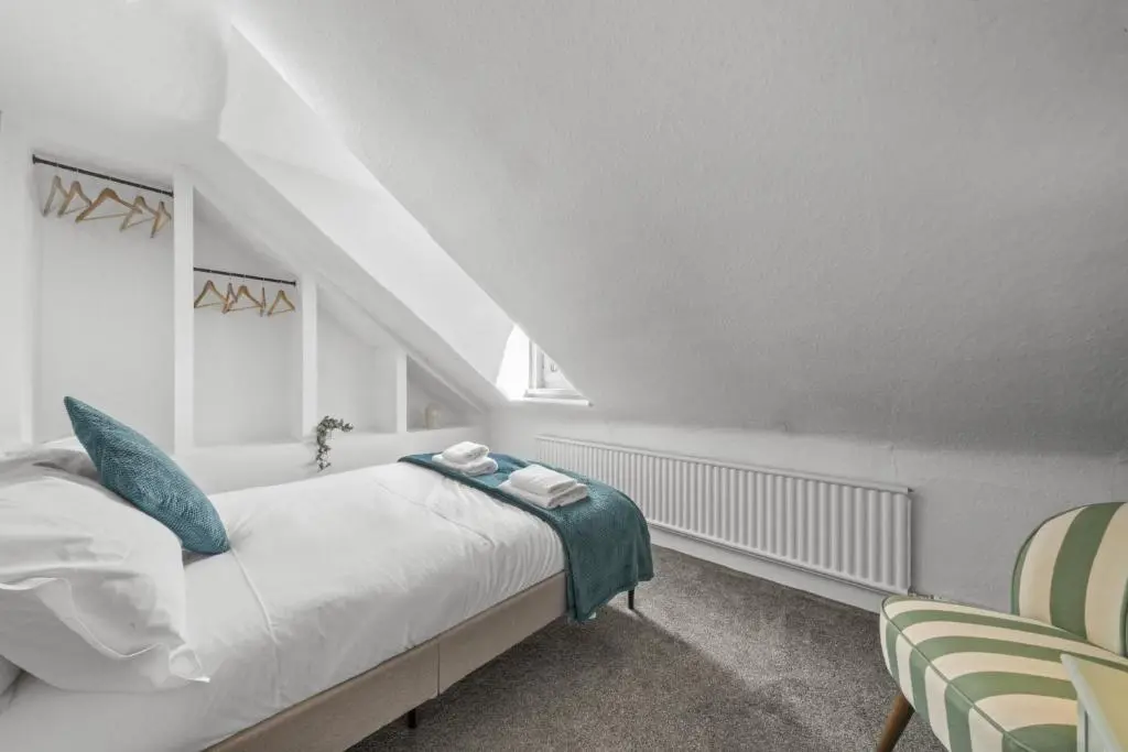 a white bedroom with a bed and a chair at Crown 3 Bedroom Apartment - Inverness in Inverness