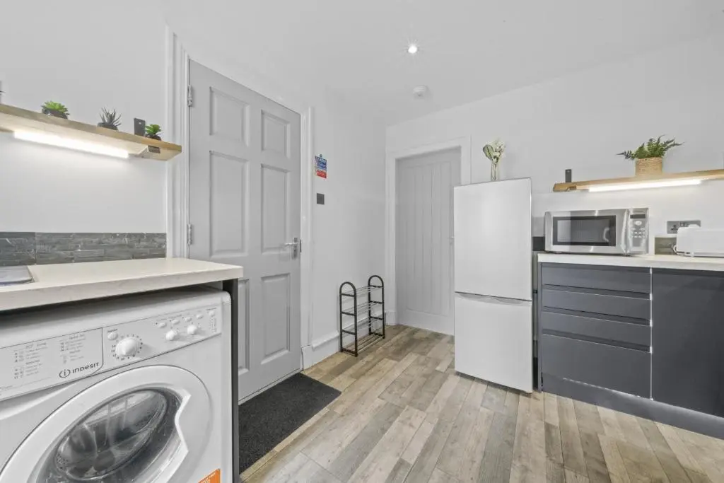 a kitchen with a washing machine and a refrigerator at Crown 3 Bedroom Apartment - Inverness in Inverness