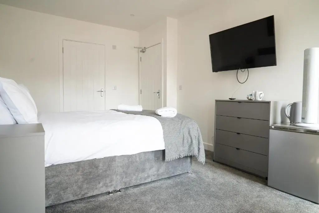 a bedroom with a bed and a flat screen tv at Taigh Mor in Elgin