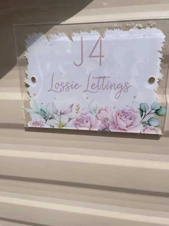 a white cake with pink flowers on it at J4 Lossiemouth Bay Caravan Park in Lossiemouth
