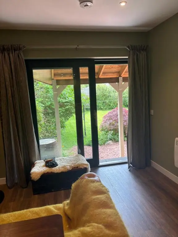 a living room with a large glass door with a view at The Studio at Rannagowan in Ballater