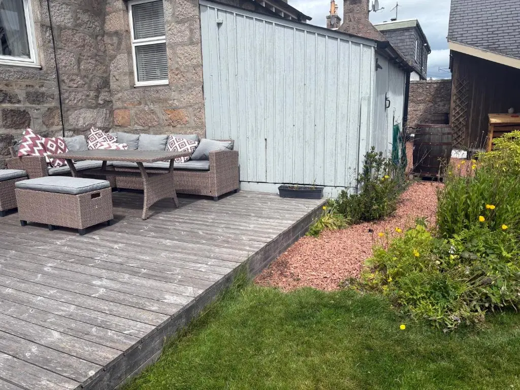 a patio with two chairs and a bench on a deck at The Studio at Rannagowan in Ballater