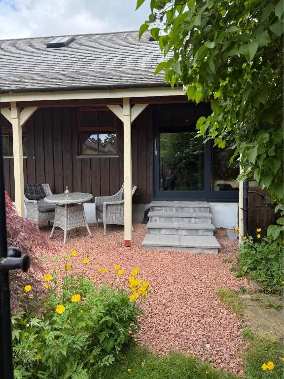 a pavilion with a table and chairs in a yard at The Studio at Rannagowan in Ballater