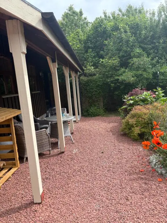 a porch of a house with a table and flowers at The Studio at Rannagowan in Ballater