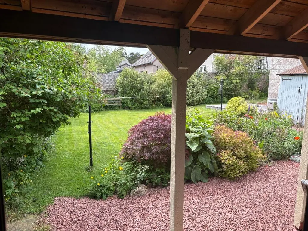 a view of a garden from the porch of a house at The Studio at Rannagowan in Ballater
