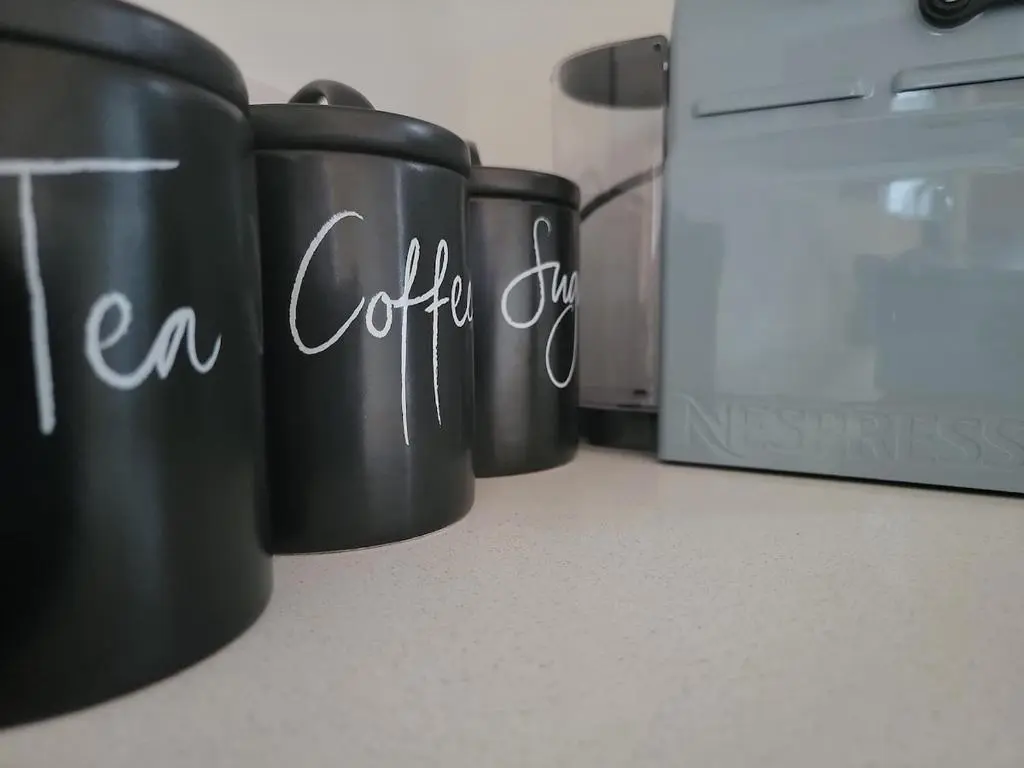 two black coffee cups on a counter next to a refrigerator at 'Wee Smiddy' Shepherd's Hut - Sauna - Yoga - Wild Swim in Skye of Curr