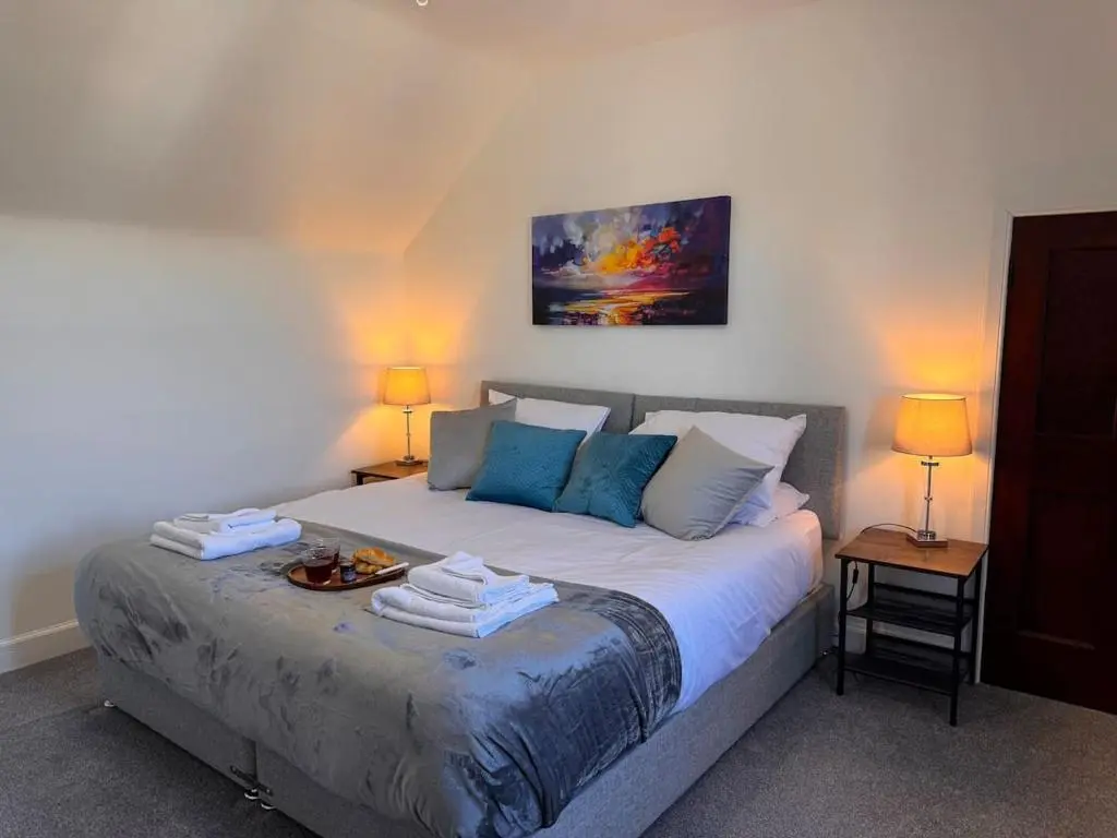 a bedroom with a bed with a tray of food on it at Coorie House in Elgin in Elgin