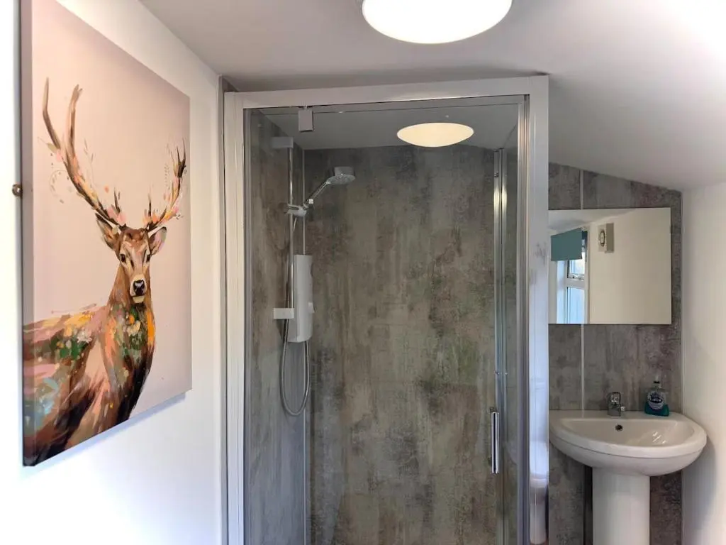 a bathroom with a painting of a deer on the wall at Coorie House in Elgin in Elgin