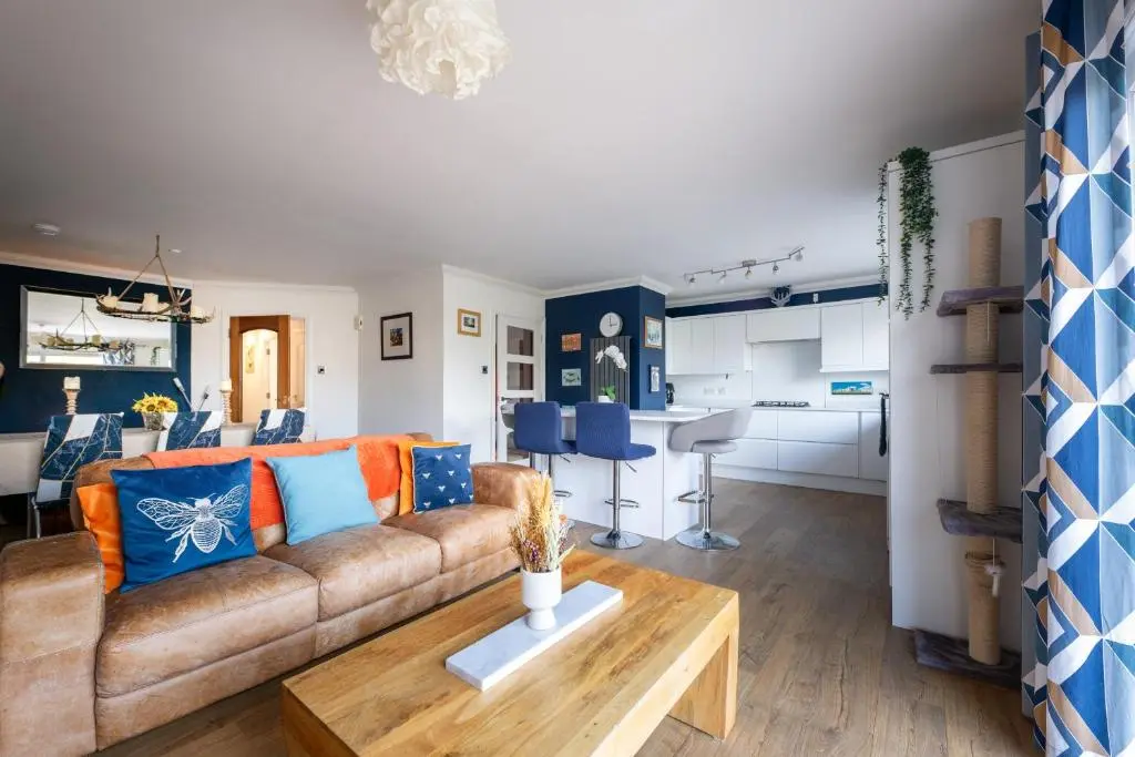 a living room with a couch and a table at Lochnomore - A Luxury Home With Magnificent Views in Nairn