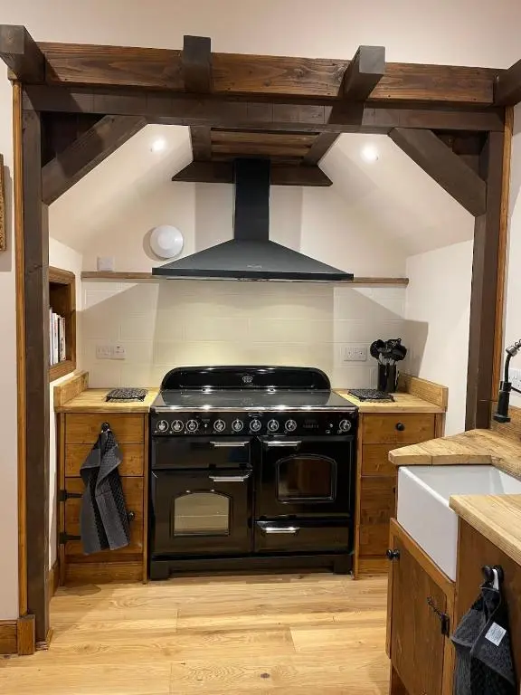 a kitchen with a stove and a hood at Church Brae in Tomatin