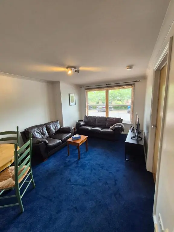 a living room with a couch and a table at Riverside Gardens in Dalneigh
