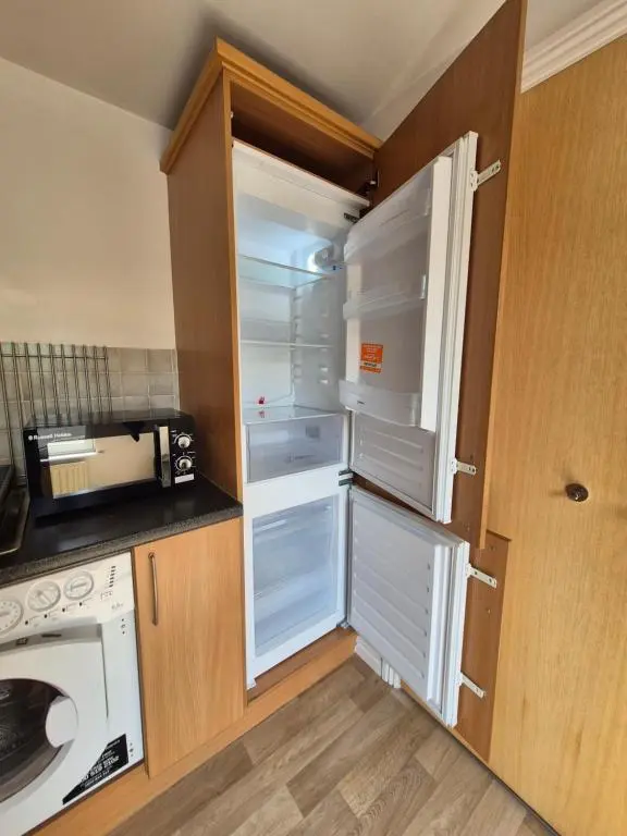 an empty refrigerator with its door open in a kitchen at Riverside Gardens in Dalneigh
