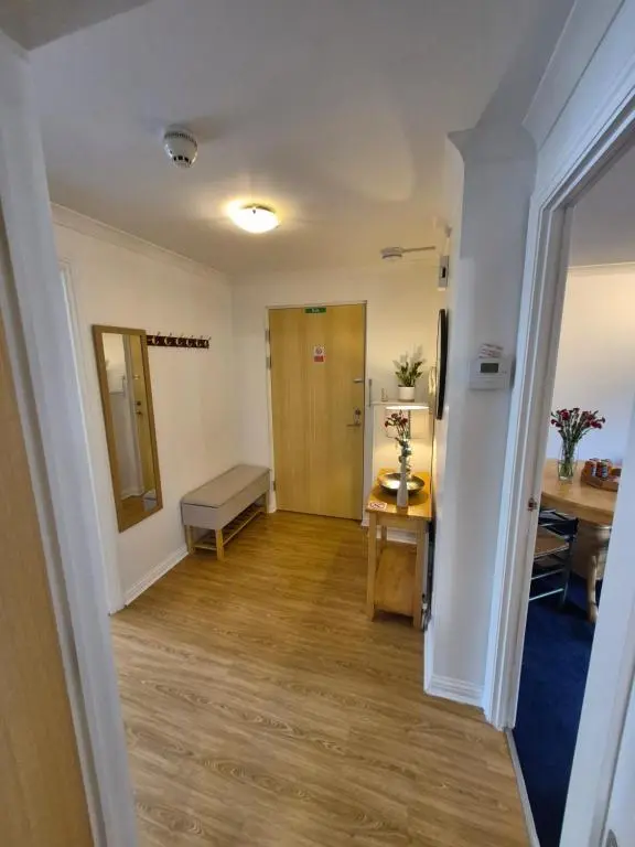 a hallway with a room with a table and a mirror at Riverside Gardens in Dalneigh