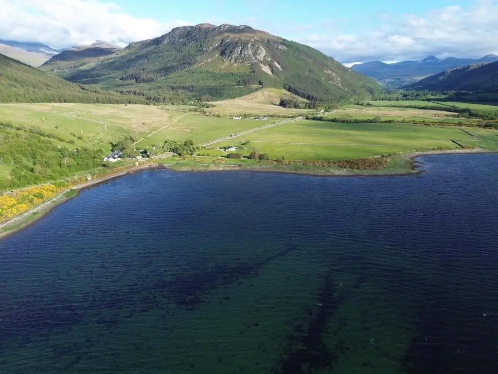 an island in the middle of a large body of water at Lochend Pods - Deas Pod in Inverlael
