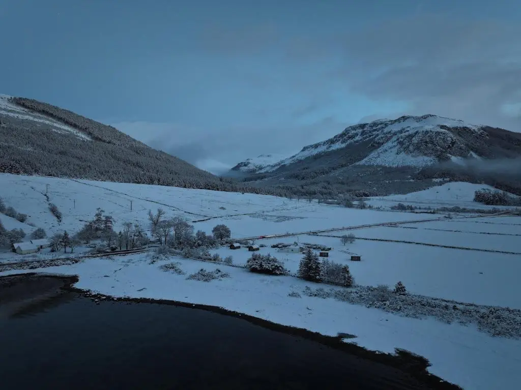 a snow covered valley with a river and mountains at Lochend Pods - Cl\u00ec Pod in Inverlael