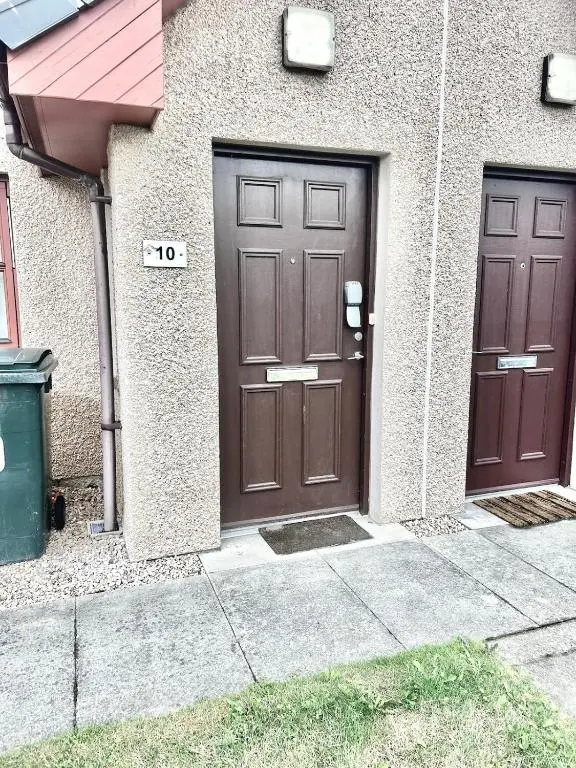 two brown doors on the side of a building at Coz, 2Bed Central Elgin - Free parking, WiFi in Elgin