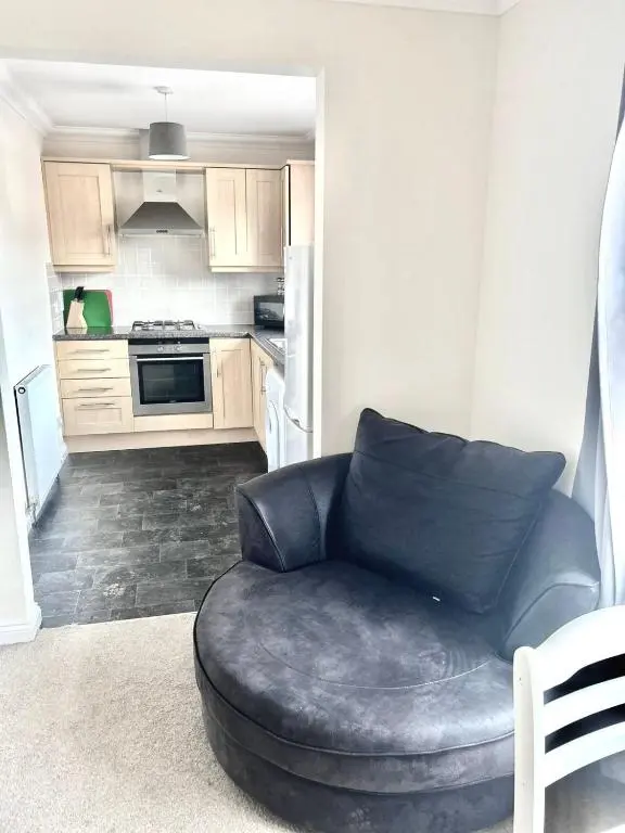 a living room with a couch and a kitchen at Coz, 2Bed Central Elgin - Free parking, WiFi in Elgin
