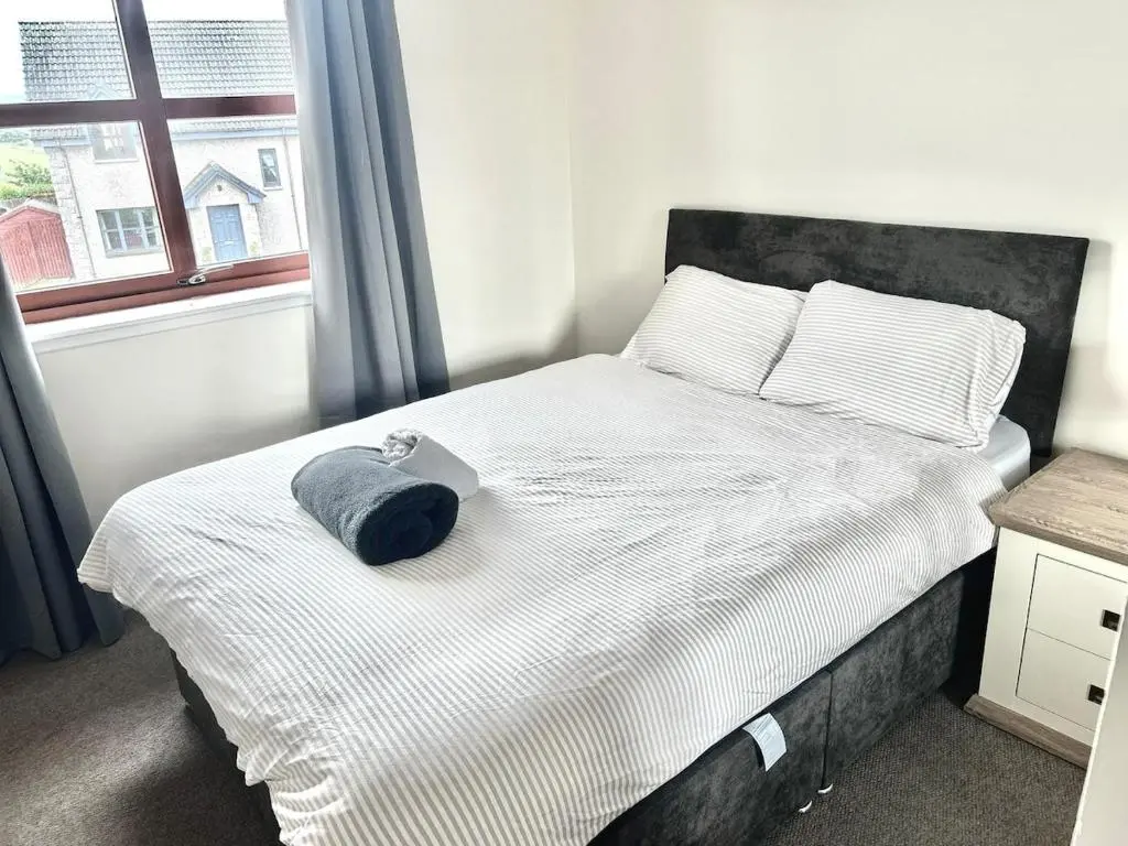 a bed with a blue hat on top of it at Coz, 2Bed Central Elgin - Free parking, WiFi in Elgin